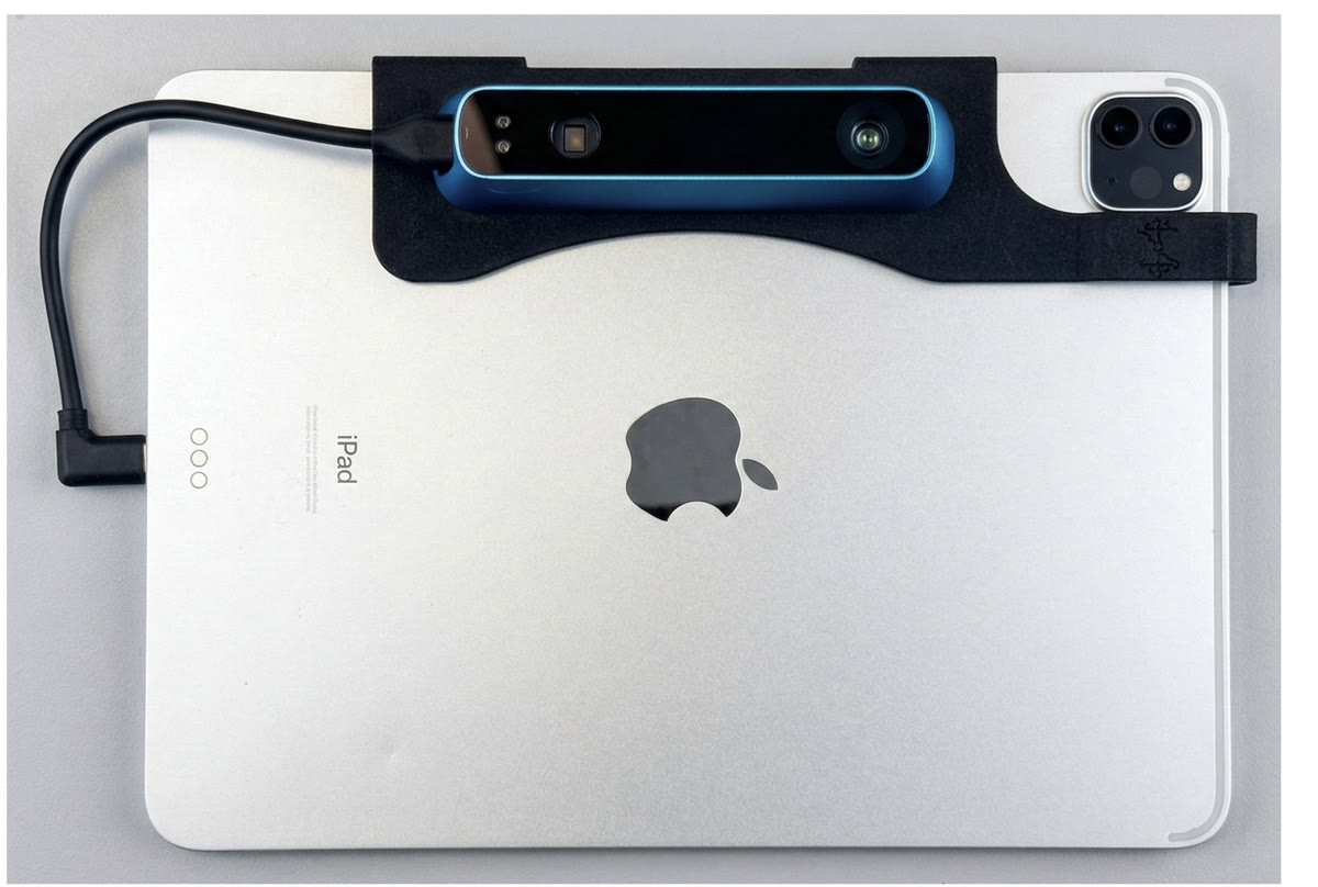 An iPad Pro with a Structure Sensor depth camera mounted on the back in a black bracket, connected by a short cable.